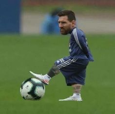 a man kicking a soccer ball on top of a field