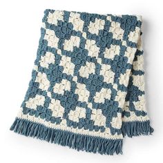 a blue and white crocheted blanket with tassels on the ends is shown