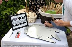 a person is writing on a star wars darth vader replica at an outdoor event