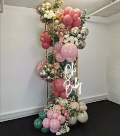 the balloon column is decorated with flowers and balloons for baby's first birthday party