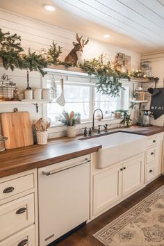 a kitchen with white cabinets and wooden counter tops, christmas decorations on the window sill