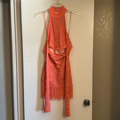 an orange dress hanging up on a door