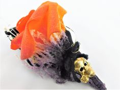 there is a fake skull on top of a flower with orange and black flowers in it