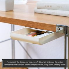 an open drawer under a desk with books on it