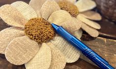 a blue pen sitting on top of a flower