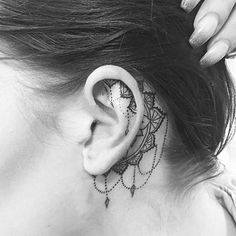 a woman's ear has a tattoo on it