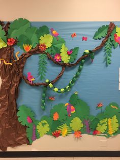 a bulletin board with paper flowers and leaves on the bottom, an image of a tree