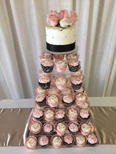 a wedding cake and cupcakes on a table