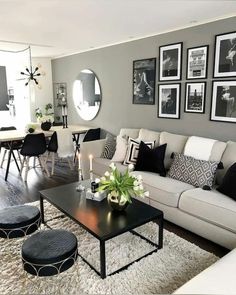 a living room filled with lots of furniture and pictures on the wall above it's coffee table