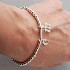 This is my new go to bracelet. Made for easy wear with high quality stretchy cord. Sterling silver beaded bracelet with a sterling bar. Silver initials dangle perfectly. Wear it alone or layered up! So cute. Listing is for one bracelet. **Please leave initial choices in notes at checkout** Comes in a Organza bag, gift box available or additional $2 PLEASE NOTE WHEN ORDERING, MEASURE YOUR WRIST, THEN ADD 1/2 INCH FOR A COMFORTABLE FIT. bracelet is adjustable by 1/2 inch. x-small 5-6 inches small Silver Stackable Charm Bracelet For Everyday, Adjustable Sterling Silver Stretch Bracelet Gift, Personalized Silver Beaded Bracelets For Everyday, Silver Minimalist Stretch Bracelet As Gift, Everyday Stackable Sterling Silver Stretch Bracelet, Everyday Sterling Silver Stackable Stretch Bracelet, Everyday Stackable Sterling Silver Bracelet, Adjustable Silver Name Bracelet With Letter Beads, Adjustable Sterling Silver Charm Bracelet With Initials