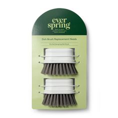 two white and gray brushes sitting on top of a green package with the words ever spring written