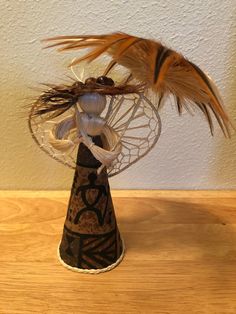 a decorative vase with feathers in it on a table