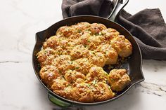 a pan filled with food sitting on top of a counter next to a napkin and fork