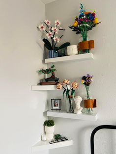 three white shelves with flowers and pictures on them