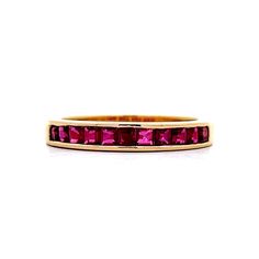 a yellow gold band with pink tourmaline stones