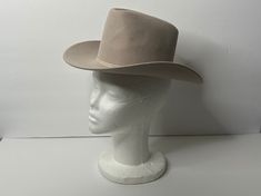 Vintage, circa 1980s, beige rockmount ranch wear cowboy / cowgirl hat.  Adult size XS.  100% wool.  Ribbon accent. Please note, this is a vintage item and does show signs of ware such as small discolorations and bends in shape.  Please view photos for condition.   In overall good vintage condition. Approximate measurements: 13" long x 11.5" wide x 5.5" tall with 20.5" circumference where upper meets brim (ribbon level) Ranch Wear, Western Hat, Cowgirl Hat, Western Hats, Cowboy Cowgirl, Cowgirl Hats, Cowboy And Cowgirl, Vintage Western, View Photos