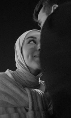 a black and white photo of a woman with a headscarf on her head