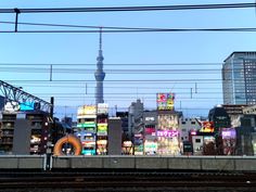 the city skyline is lit up at night with neon signs and buildings in the background