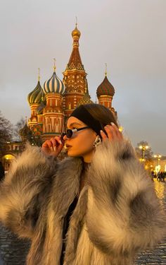 a woman in a fur coat talking on her cell phone