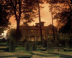 an old cemetery with many headstones in the foreground and trees on either side