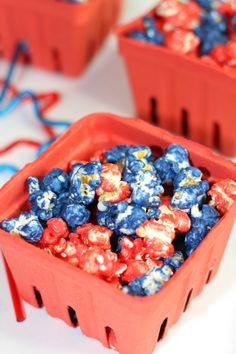 blueberries and strawberries are in red plastic containers