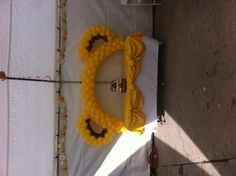 a table topped with yellow balloons under a tent