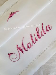 embroidered name on white cloth with pink flowers