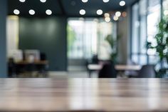 an empty wooden table with blurry lights in the background