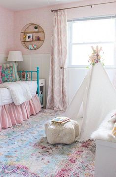 a child's bedroom decorated in pink, white and blue with a teepee tent