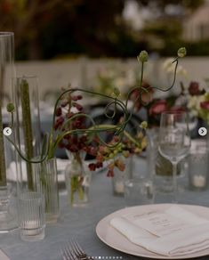 the table is set with flowers, candles and place settings for an elegant dinner party