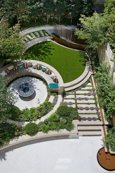 an aerial view of a circular garden with benches and seating area in the center, surrounded by greenery