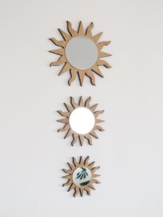 three mirrors mounted to the side of a wall