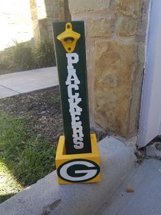 a green bay packers sign on the side of a building with a yellow hook in it