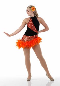 a woman in an orange and black dress is posing with her hands out to the side