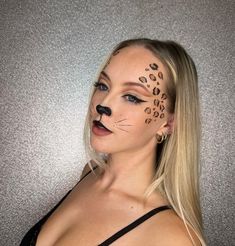 This bold cat makeup look is all about channeling your inner wildcat. The striking leopard spots drawn across the forehead and cheek create a fierce and realistic effect. The sharp, black eye liner and the dramatic winged lines accentuate the eyes, giving a powerful gaze. The black nose and whiskers add a finishing touch, making this look perfect for a Halloween party. The black outfit complements the makeup, enhancing the overall wild aesthetic. This look is relatively easy to achieve with a bit of practice and is sure to turn heads at any event.   Photo credit by: @abby.pipp Animal Makeup Looks Halloween, Black Makeup Looks Halloween, Cat Make Up For Halloween Easy, Easy Makeup Looks Halloween, Leapord Halloween Makeup Easy, Leapord Print Makeup Look, Black Leopard Makeup, Easy Leopard Makeup, Halloween Cat Make Up