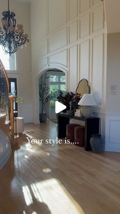 the inside of a house with wood flooring and white walls, chandelier