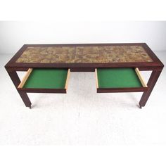 a wooden table with two green trays on it's sides and an open drawer underneath