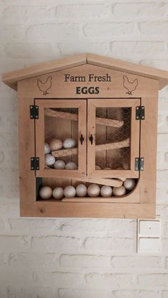 an egg carton with eggs in it hanging on the wall next to a brick wall