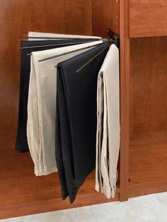 there are several folded clothes hanging on the cabinet door handle, which is also attached to the wall