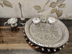 an ornate silver tray with three candles on it