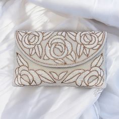 Ivory Clutch, White Clutch, Beaded Floral Clutch, Evening Bag, Brides Purse, Ideal for Weddings and Parties, Clutch Purse, Gift Idea, Christmas Gift,  This stunning handmade bridal clutch is a true masterpiece of elegance and craftsmanship. Made with raw silk and featuring intricate beading and crystal floral work, this clutch is designed to be the perfect accessory for your special day. The beautiful beaded design adds a touch of glamour, while the crystal floral motifs provide a delicate, roma Elegant Embroidered Cream Evening Bag, Elegant Embroidered Beige Clutch, Elegant Cream Embroidered Evening Bag, Handmade Chic Clutch, Elegant Beige Wedding Clutch, Handmade Beige Clutch For Events, Elegant Handmade Beige Clutch, Luxury Cream Clutch For Wedding, Beige Embellished Clutch For Wedding