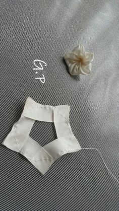 two pieces of white fabric next to a flower