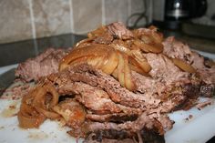 sliced meat and onions on a cutting board in the middle of a kitchen counter top