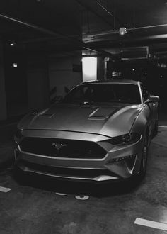 a black and white photo of a car in a parking garage