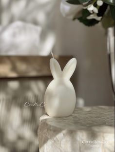 a small white bunny shaped candle holder on a table