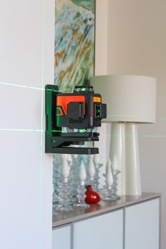 a camera mounted to the side of a wall next to a lamp and vases