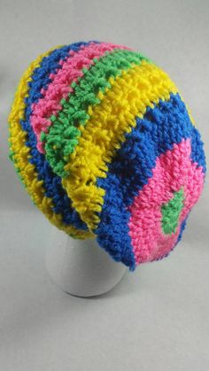 a multicolored knitted hat sitting on top of a white mannequin head