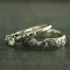 two wedding rings sitting next to each other on a table