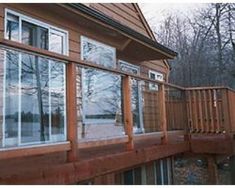 an outside view of a house with wood sidings and glass windows on the second floor