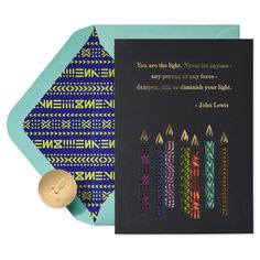 a card with candles on it next to a gold wax stamp and a blue envelope that says, you are the light